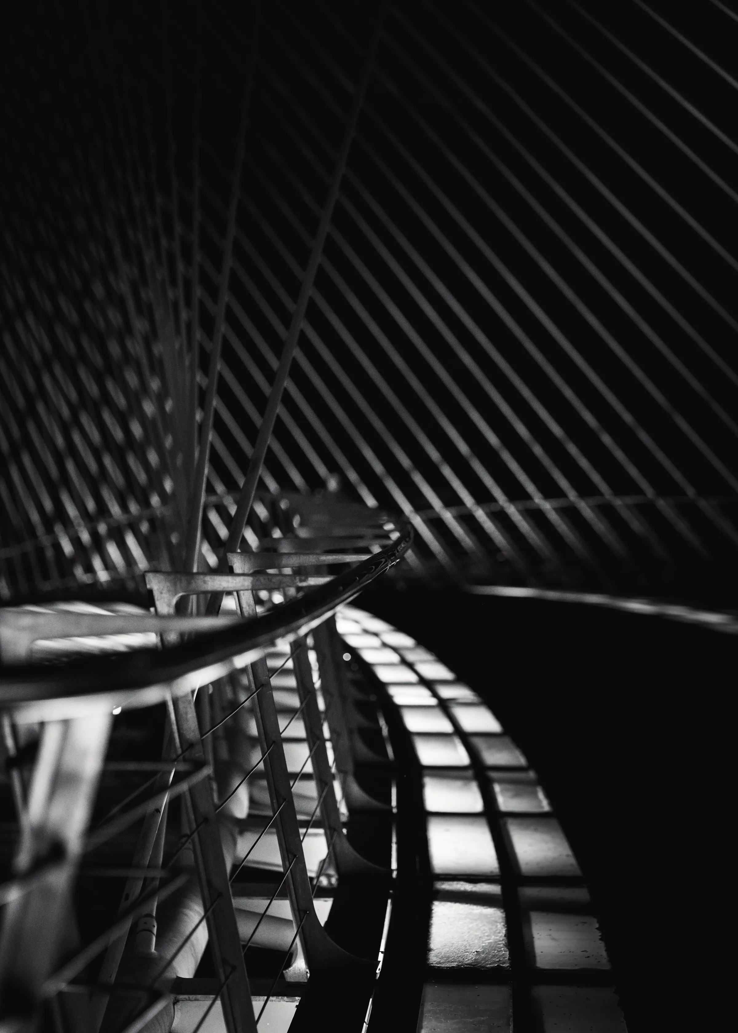 Diagonal bridge ribs cast striped shadows across a walkway.